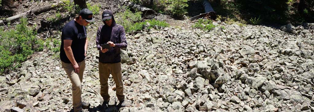 Two planners studying a map in a talus field 