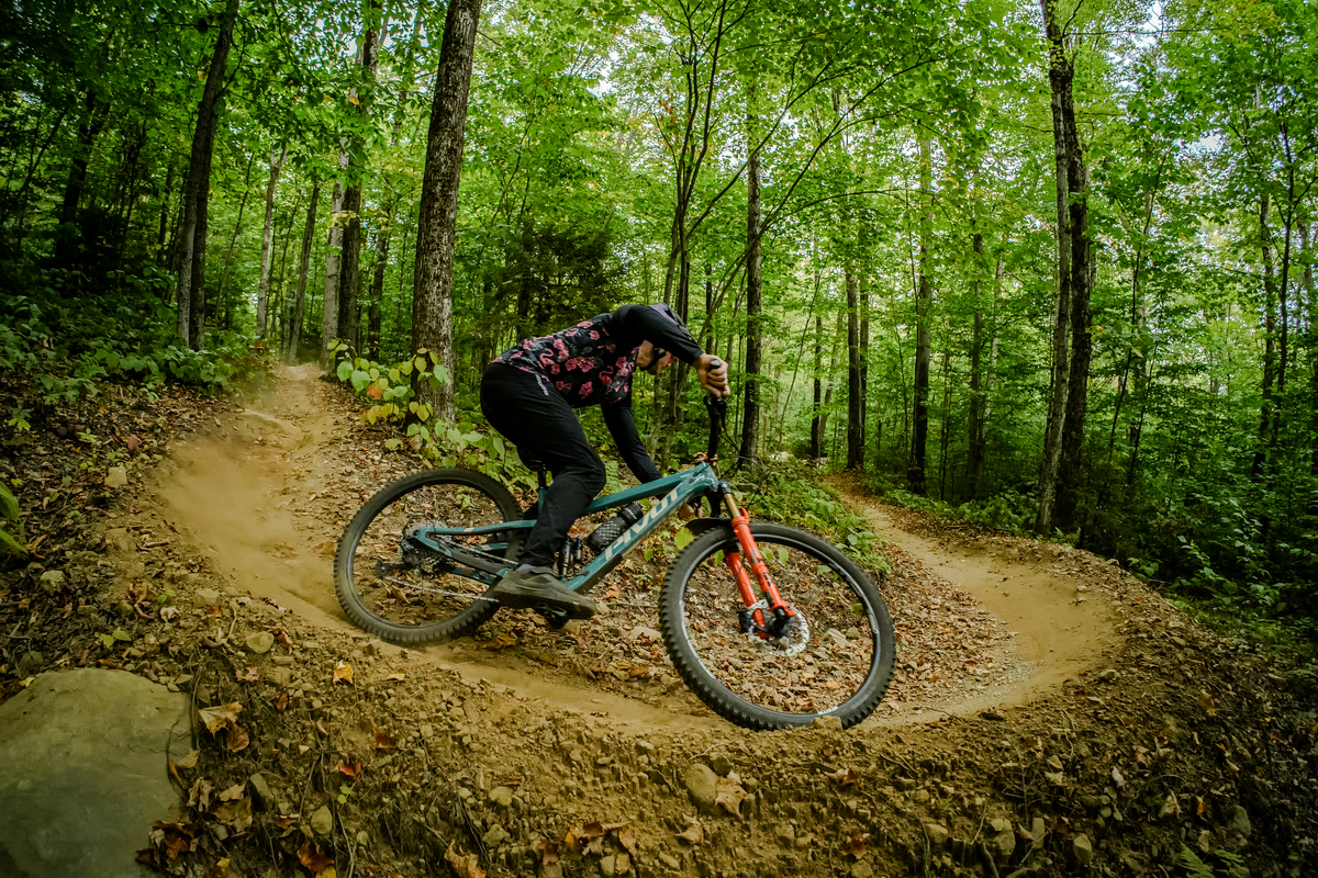 Author, Brice Shirbach, rides a berm through the VT forest, shot through a wide angle lens.