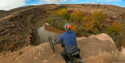 PHOTO OF ADAPTIVE MOUNTAIN BIKE RIDER LOOKING OUT OVER HURRICANE CLIFFS MOUNTAIN BIKE TRAIL SYSTEM VISTA
