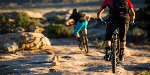 Mountain bikers riding on some rocky singletrack on southwestern U.S. public lands. 