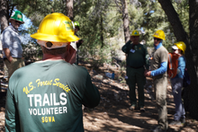 A USFS staff member learns how to use a clinometer during an IMBA Trail Care School