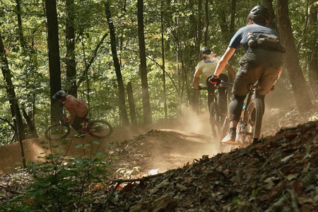 Three mountain bikers riding fast around a corner in Chattanooga, TN.