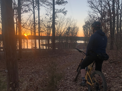 Person looking out at lake from mountain biking trails in in Jonesboro, Arkansas.