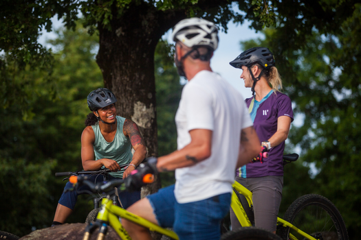 Three mountain bikers talking mid-ride.