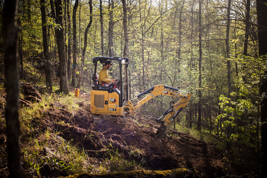IMBA trail solutions machine operator on excavator building new trail